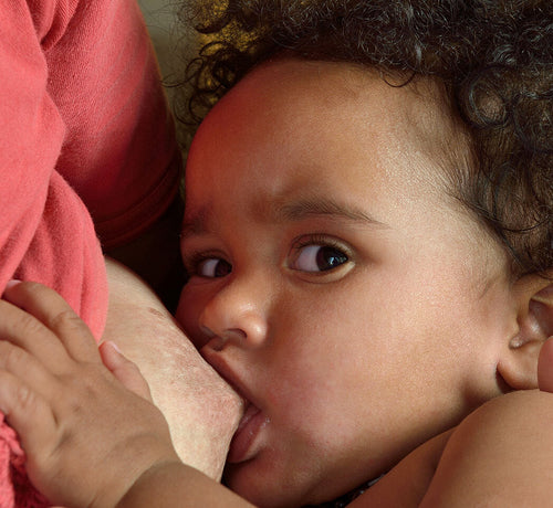 Bebé alimentándose del pecho de su madre donde se aprecian las típicas grietas del pezón. - solucionesbanohub.compaña - 1