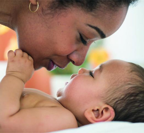 Una mamá da besos y mimos a su bebé recién bañado con productos para la higiene corporal Mustela - solucionesbanohub.compaña - 1
