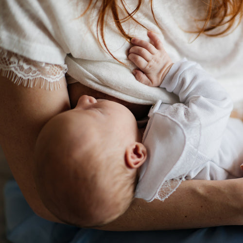 Un bebé se queda dormido plácidamente en los brazos de su madre mientras mama. - solucionesbanohub.compaña - 1