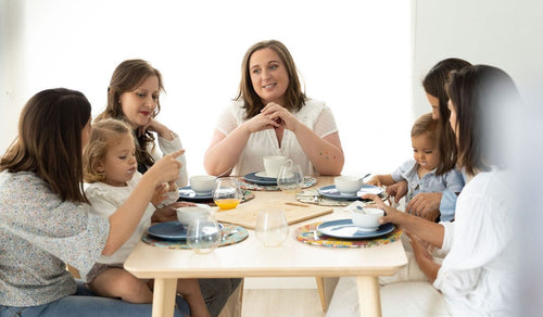 Madres y sus hijas comiendo en una mesa. - solucionesbanohub.compaña - 1