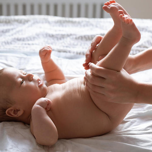 Una mamá ayuda a su bebé a combatir el estreñimiento haciendo ejercicios con sus piernas y barriguita - solucionesbanohub.compaña - 1