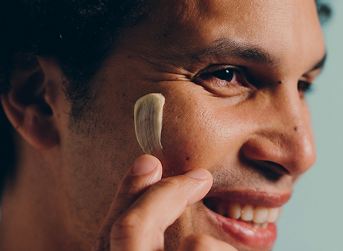 Hombre aplicándose el bálsamo universal de Mustela - solucionesbanohub.compaña - 1