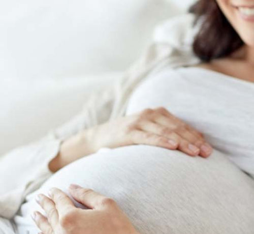 Una mujer embarazada feliz mientras se acaricia la barriga durante los últimos meses de gestación - solucionesbanohub.compaña - 1