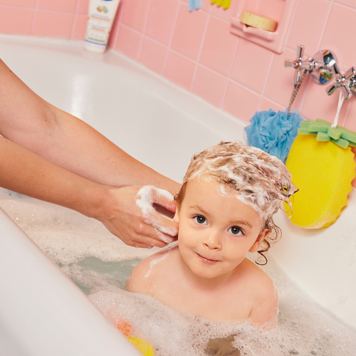 madre lavando el pelo al bebé en una bañera - solucionesbanohub.compaña - 1