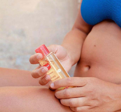 Mujer embarazada y en ropa interior aplicándose aceite para las estrías - solucionesbanohub.compaña - 1