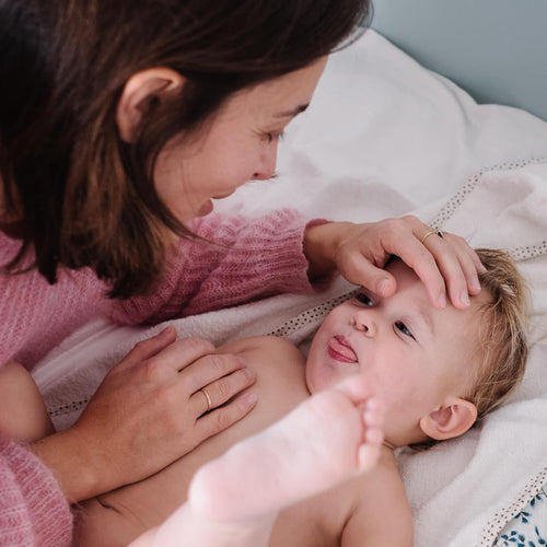 Mamá acariciando la cara de si hijo y este sacando la lengua y sube las piernas como refejo. - solucionesbanohub.compaña - 1