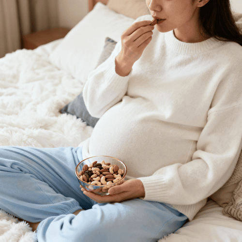 Mujer embarazada comiendo frutos secos - solucionesbanohub.compaña - 1