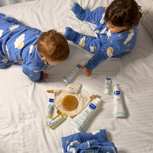 Dos bebés en una cuna con la rutina Mustela y pijamas de molis&co - solucionesbanohub.compaña - 1