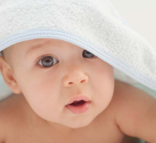Bebé tapado con una toalla después de recibir un baño de burbujas con productos de higiene Mustela - solucionesbanohub.compaña - 1