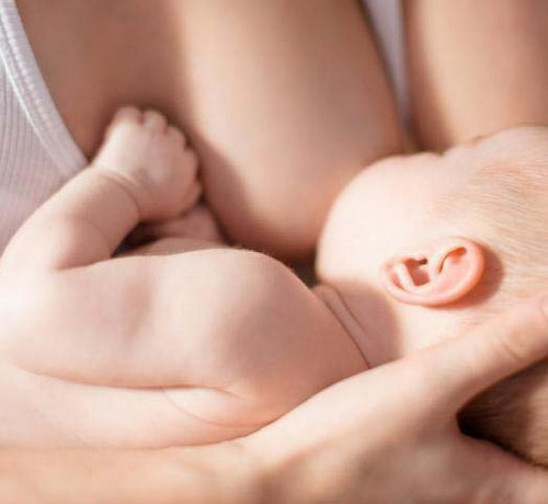 Una mamá da el pecho a su bebé mientras lo sujeta en brazos - solucionesbanohub.compaña - 1