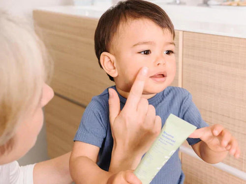 Una madre aplica el bálsamo universal de Mustela en el rostro del bebé  - solucionesbanohub.compaña - 1