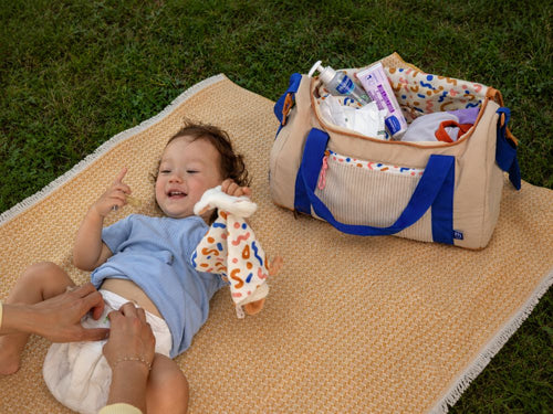 mamá cambiando el pañal en una toalla frente a la bolsa - solucionesbanohub.compaña - 3