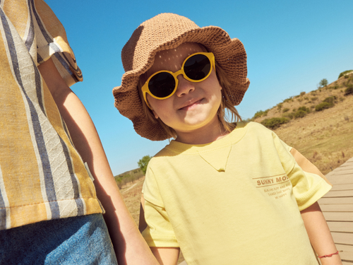 Bebé entre 1 y 2 años disfruta de un día soleado en el parque con las gafas de sol aguacate de Mustela by Parafina en color amarillo. - solucionesbanohub.compaña - 13