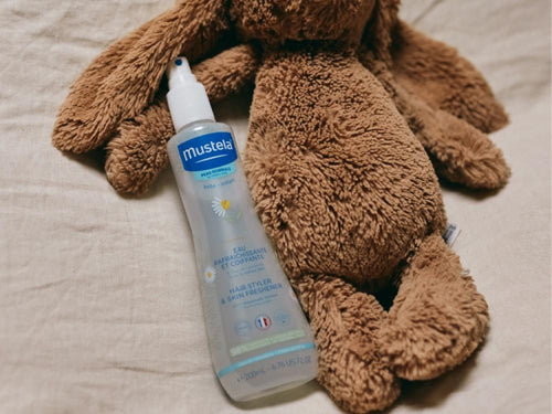 Bote de agua de peinado infantil de Mustela al lado de un peluche - solucionesbanohub.compaña - 8