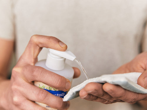 Padre aplica un poco de agua micelar Mustela en una toallita como desmaquillante - solucionesbanohub.compaña - 5