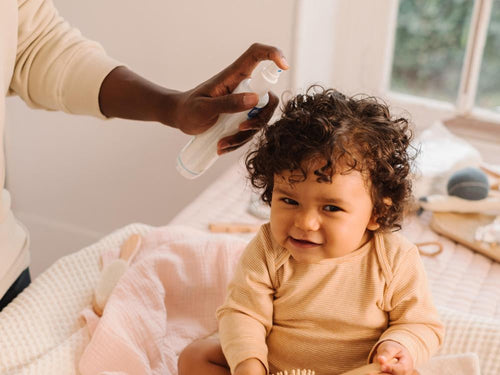 Una padre usa el Agua para peinar de Mustela en el pelo de su niña con pelo rizado. slider - solucionesbanohub.compaña - 5