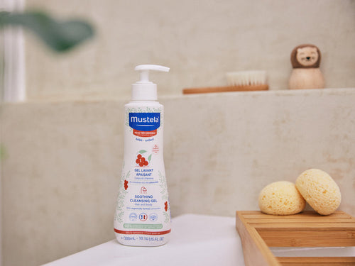 Bote de gel de baño confort de Mustela al lado de una bañera, apto para toda la familia con piel sensible o no. - solucionesbanohub.compaña - 6