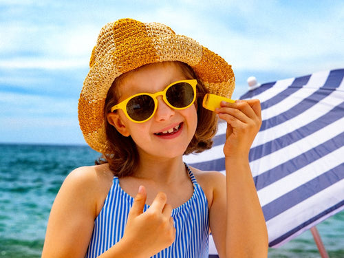 Niña disfrutando de un día de playa aplicándose el stick solar de Mustela - solucionesbanohub.compaña - 5