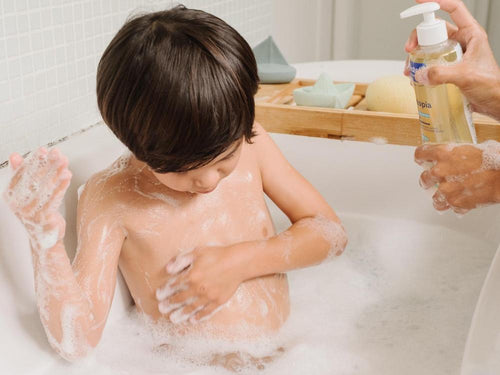 Un niño está tomando su baño con el aceite de ducha Stelatopia Mustela, que hace espuma - solucionesbanohub.compaña - 5