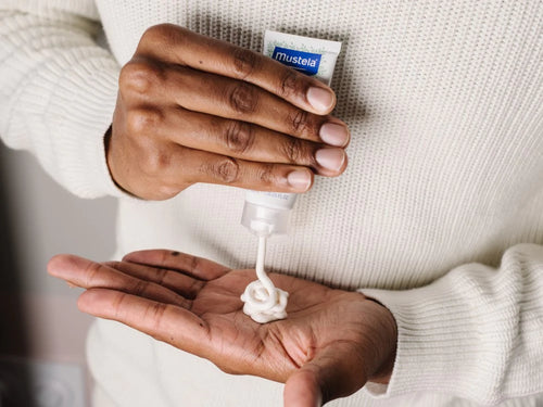 Padre se aplica un poco de crema facial para piel seca de Mustela en las manos para hidratar y nutrir la cara de su bebé. - solucionesbanohub.compaña - 5