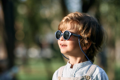 Bebé entre 1 y 2 años disfruta de un día soleado en el parque con las gafas de sol aguacate de Mustela by Parafina en color azul.  - solucionesbanohub.compaña - 3
