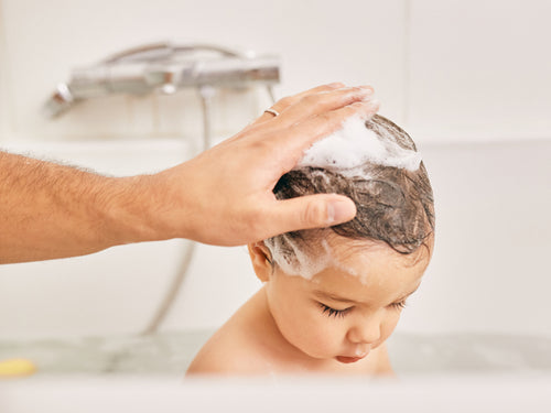 Un padre utiliza el gel de baño y ducha Stelatopia para limpiar el cabello de su niño. - solucionesbanohub.compaña - 6